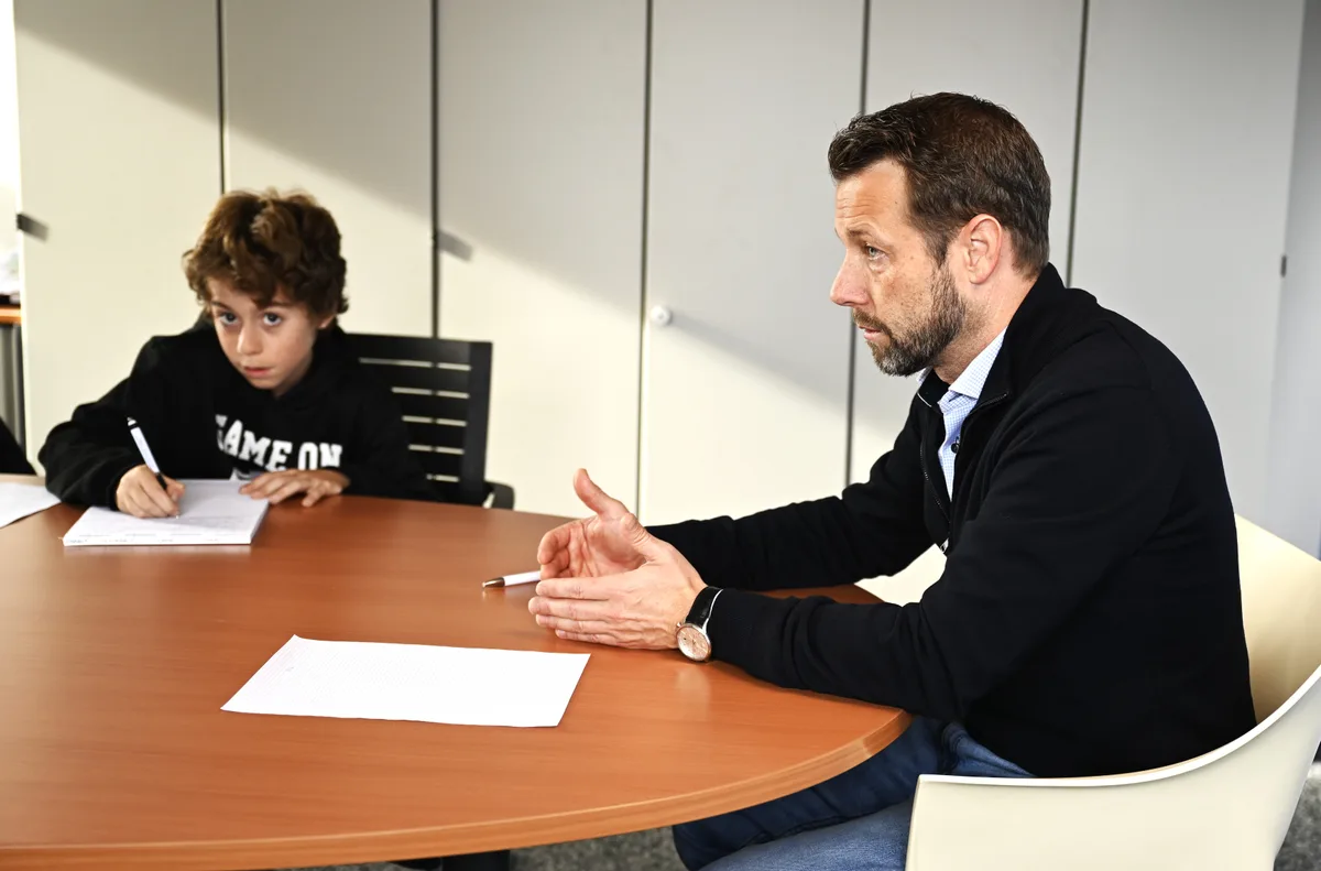 Ein Mann sitzt an einem Tisch.